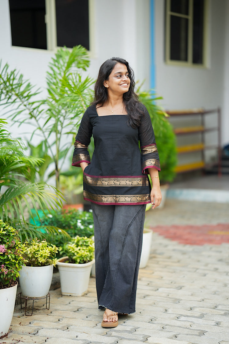 Front view of black cotton short kurti styled with wide leg trousers