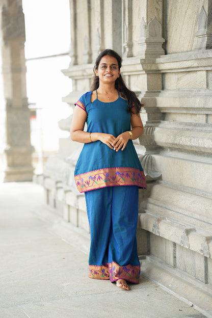 Front view of peacock blue ethnic co ord set for women with rich woven zari borders