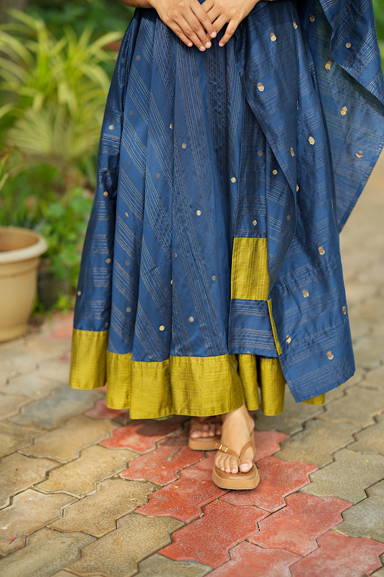 Detailed view of contrast olive hemline border on blue raw silk anarkali flare