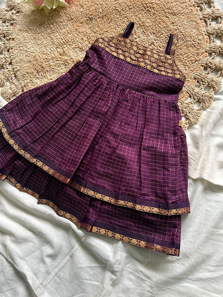 Flat lay of wine Aarani kids silk frock with double tiered zari border hem