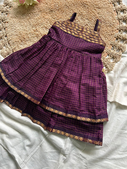 Flat lay of wine Aarani kids silk frock with double tiered zari border hem