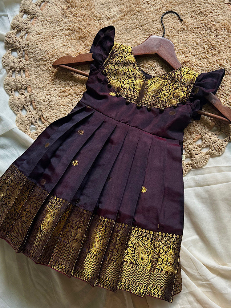 kids traditional ethnic frock hanging on display showing pleated skirt and heavy zari border
