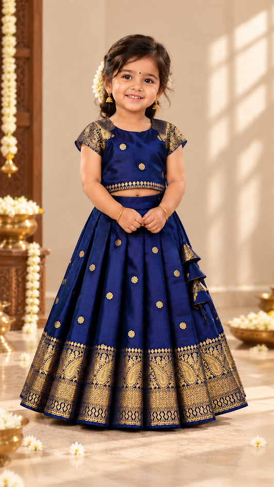 Royal blue kids pattu pavadai featuring gold zari woven motifs and traditional paisley border on the pleated skirt