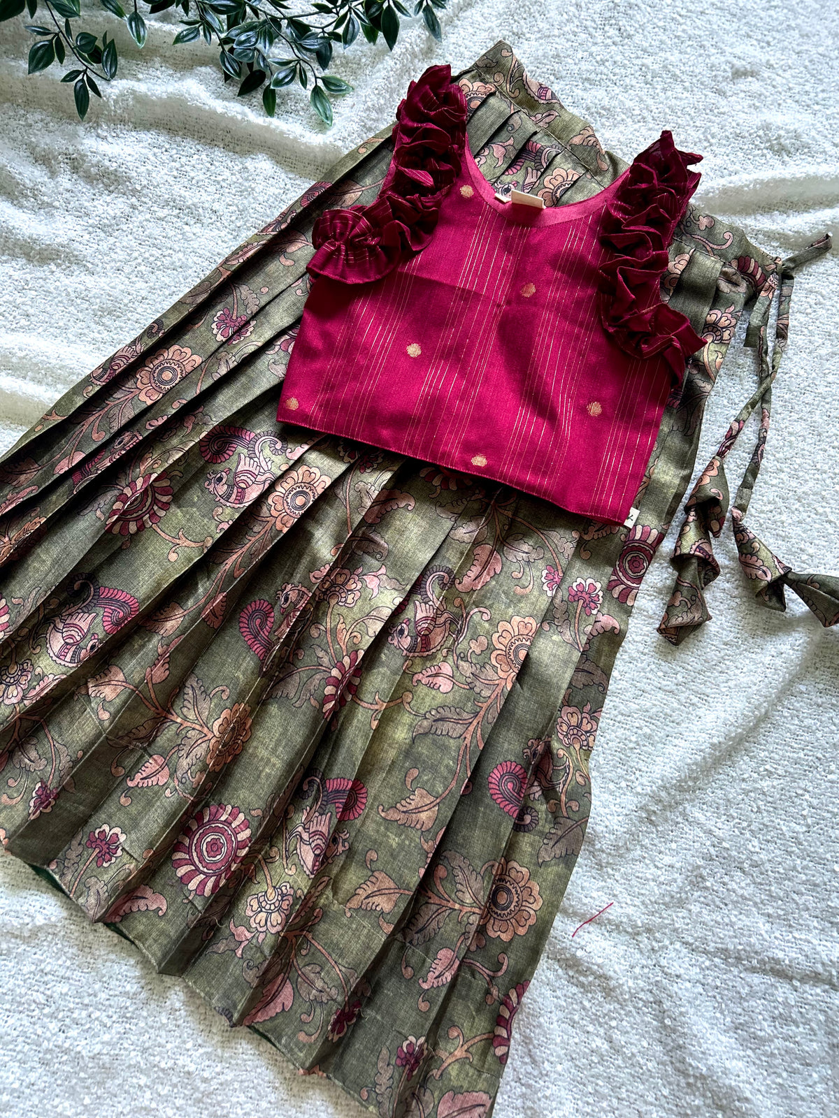 Front flat lay of maroon zari crop top and olive green pleated skirt set