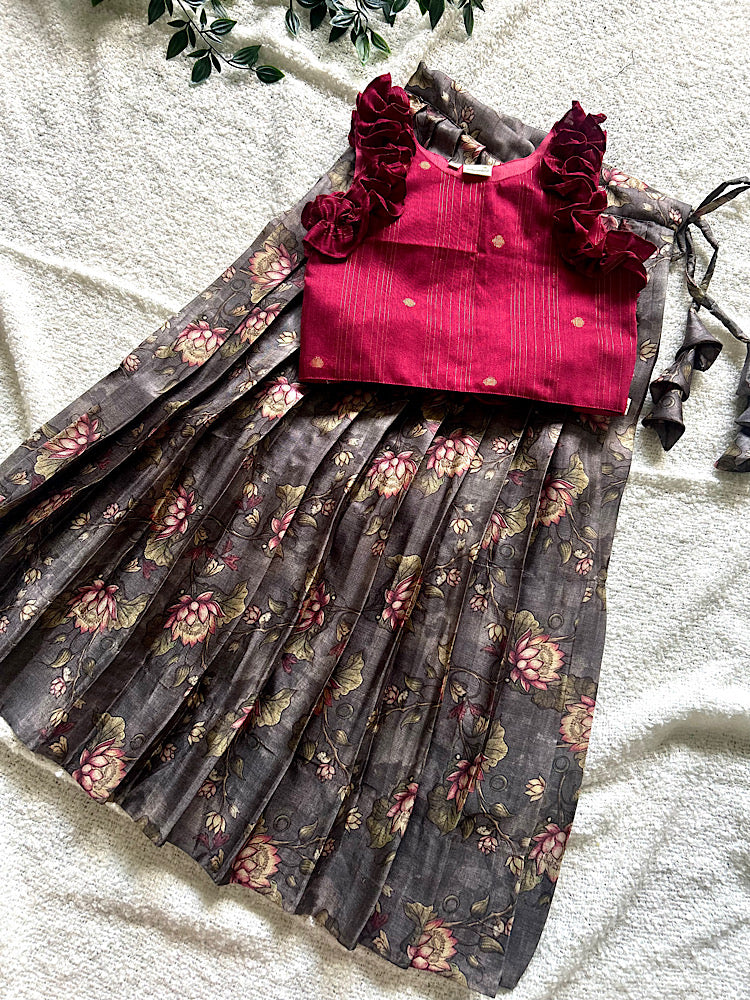 Flat lay of maroon raw silk crop top with ruffles and grey floral pleated skirt