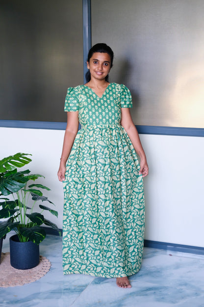 Full-length view of a green cotton nighty for women featuring a gathered waist and leafy print skirt