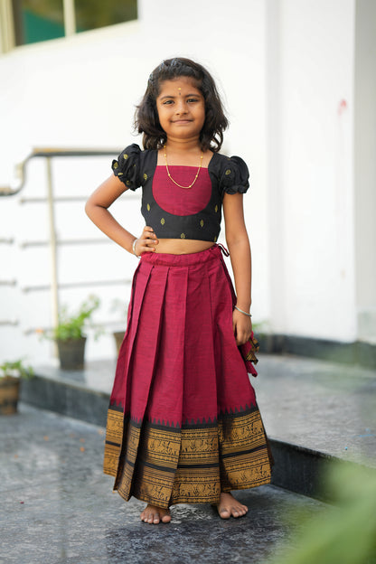 Elamathi red and black kids pattu pavadai featuring traditional zari border and pleated skirt