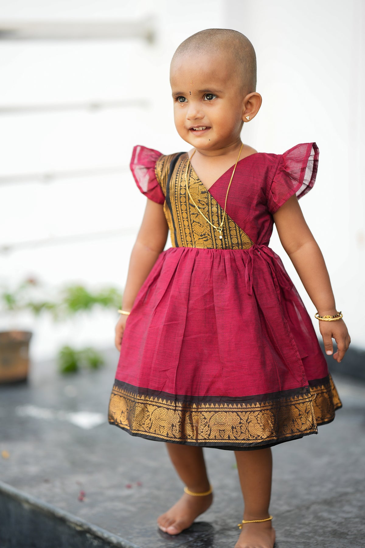 kids cotton frock - Red Chettinad cotton kids frock with traditional gold zari border and flutter sleeves, a perfect pattu frock for baby girl festive wear.
