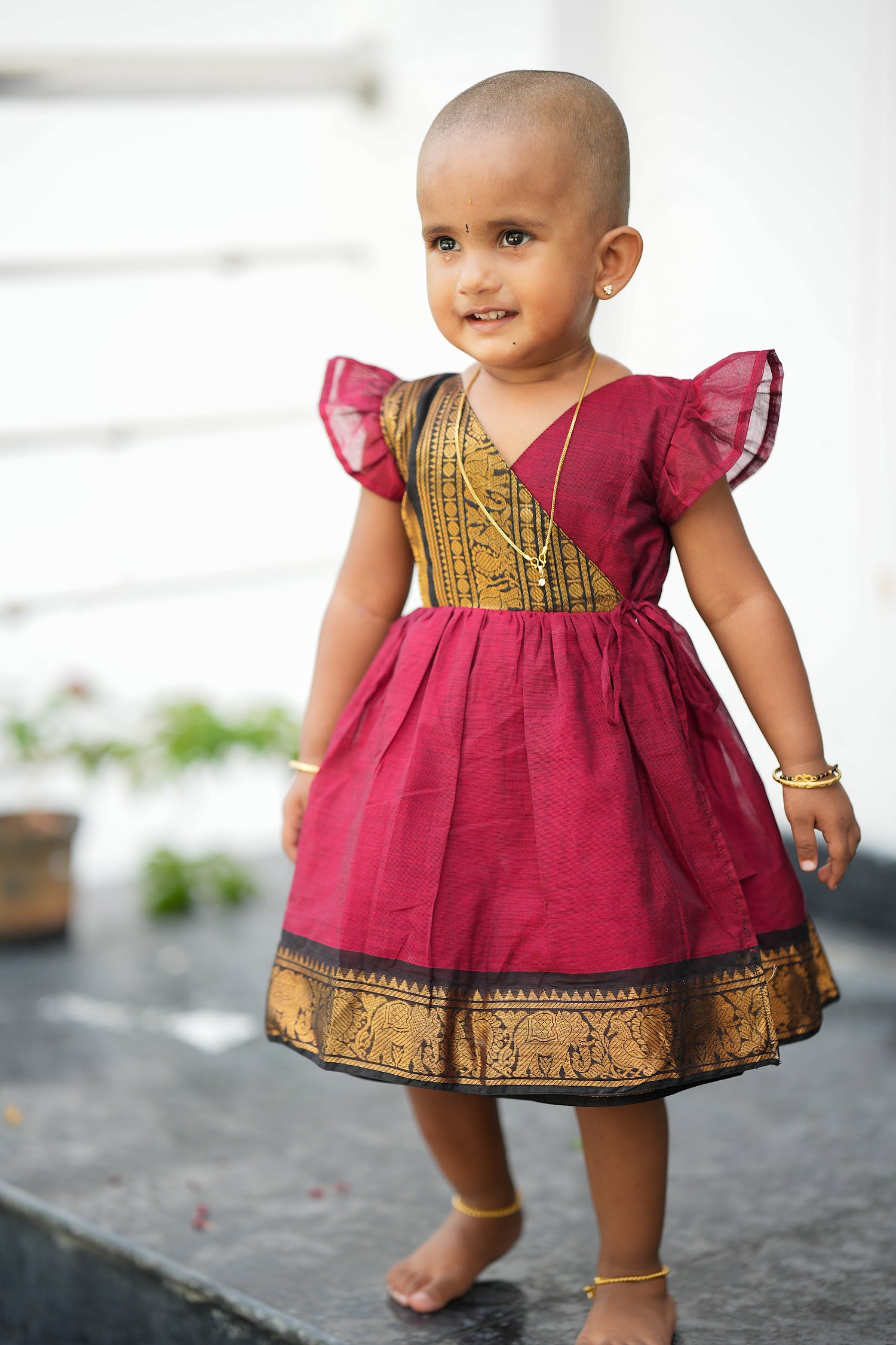 kids cotton frock - Red Chettinad cotton kids frock with traditional gold zari border and flutter sleeves, a perfect pattu frock for baby girl festive wear.