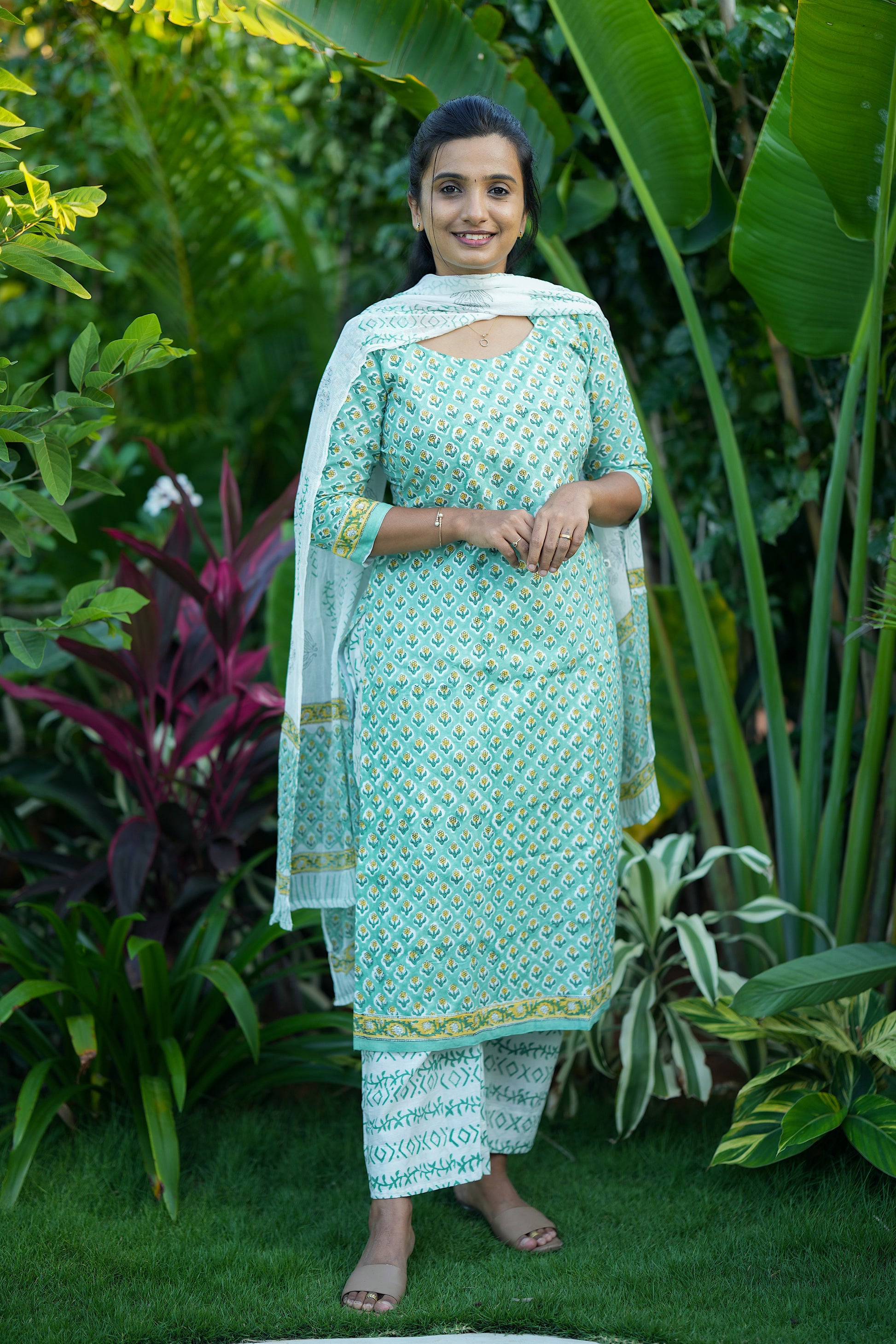 Front view of a woman wearing a mint green printed straight kurti set.