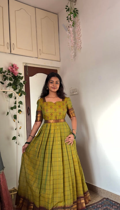 Full view of the tea green cotton anarkali dress, showing the flared skirt and traditional borders