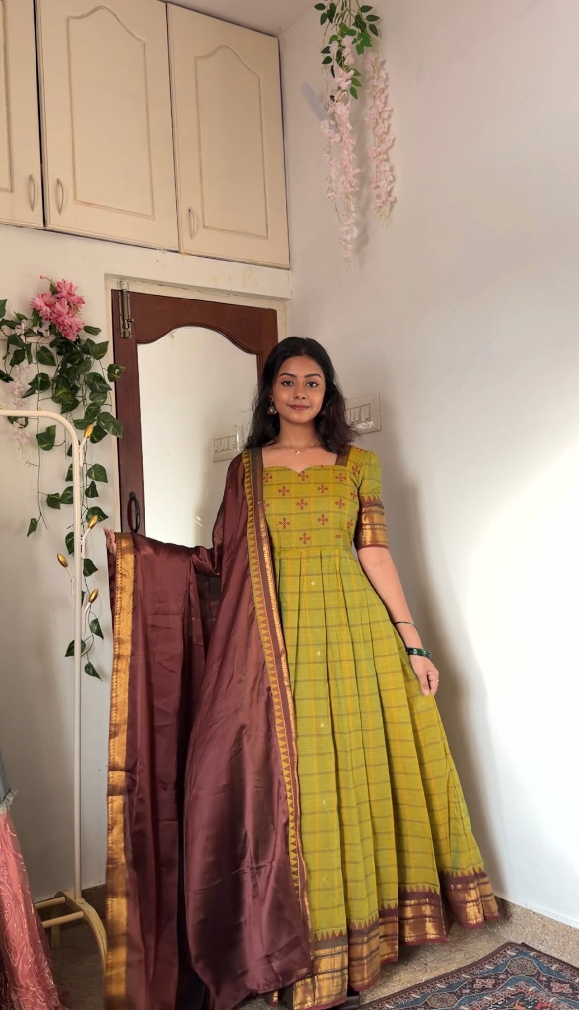 Close-up of the tea green anarkali dress and maroon dupatta with gold woven border