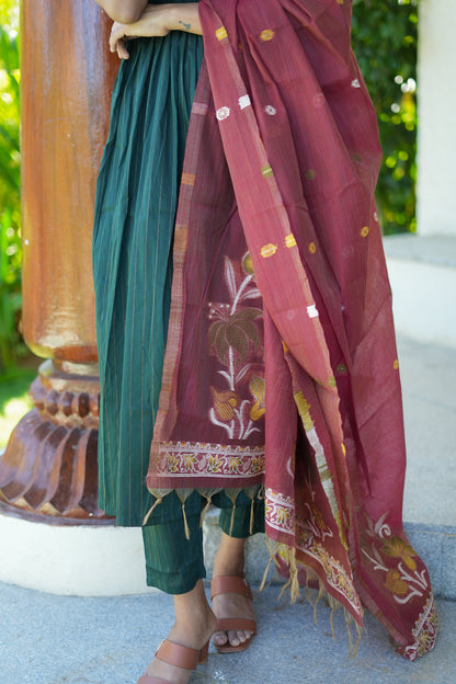 Close-up of the maroon contrast dupatta with gold woven details and tassels, draped over the bottle green raw silk kurti set.