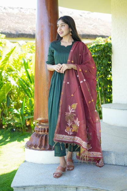 A three-piece bottle green suit set showing the gathered kurta silhouette and structured straight-cut pants.