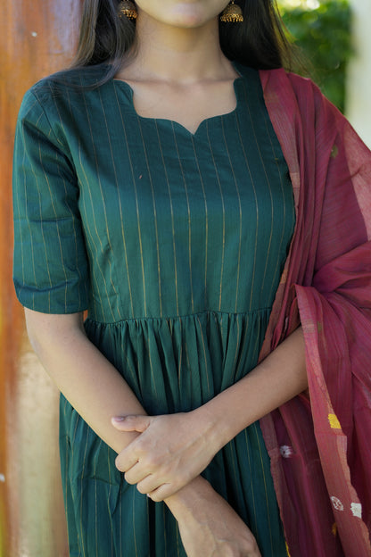 Detailed view of the notched neckline and gathered empire waist of the bottle green raw silk kurta.