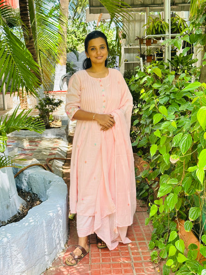 Three-piece mul cotton kurti set in pastel pink with pin tuck details on the chest.