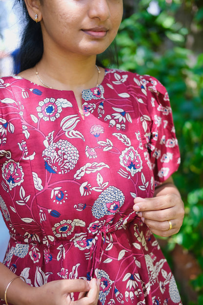 Close-up of the floral print and neckline of the maroon cotton maxi dress
