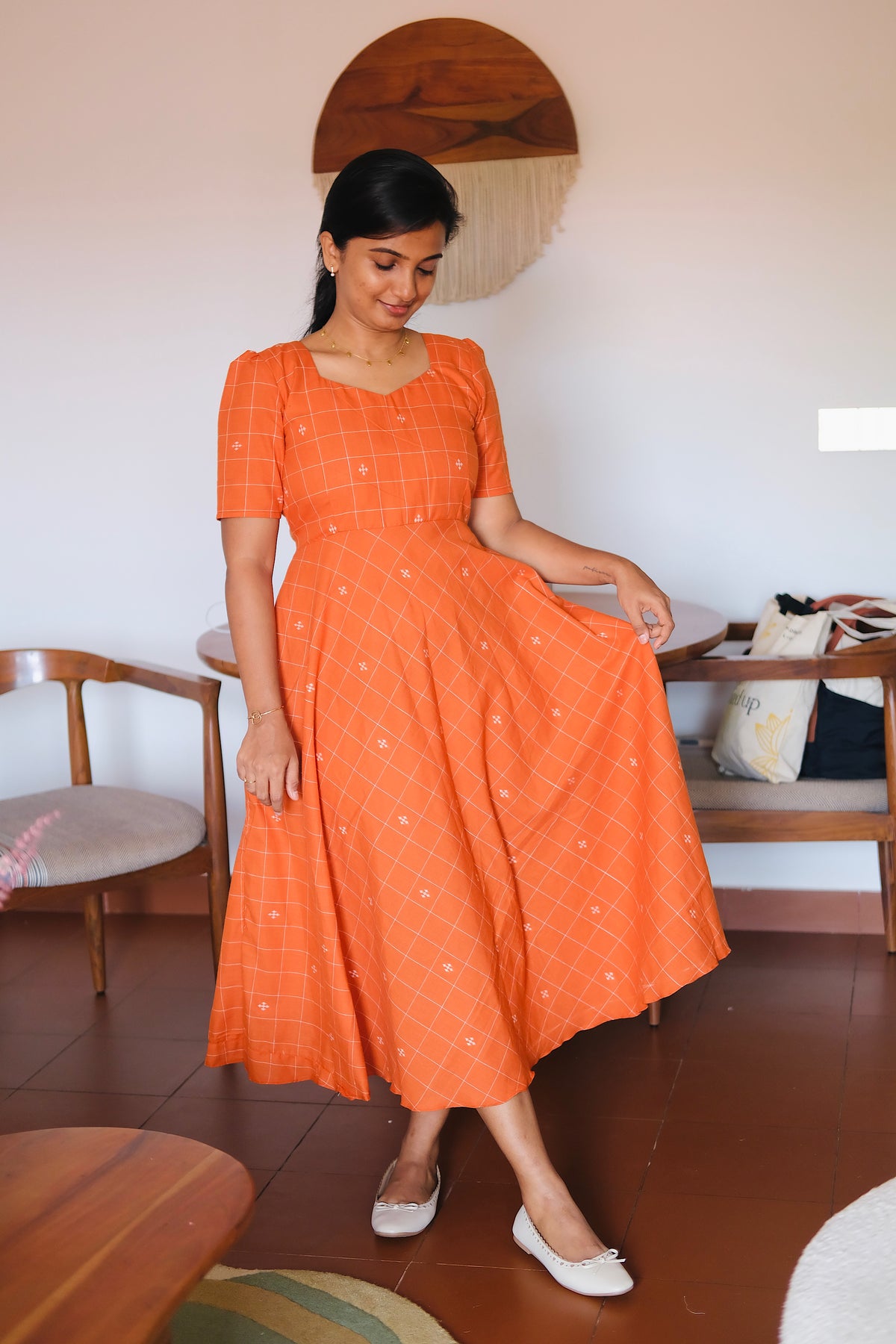 Short-sleeved rust orange patterned midi dress with a sweetheart neckline and check print.