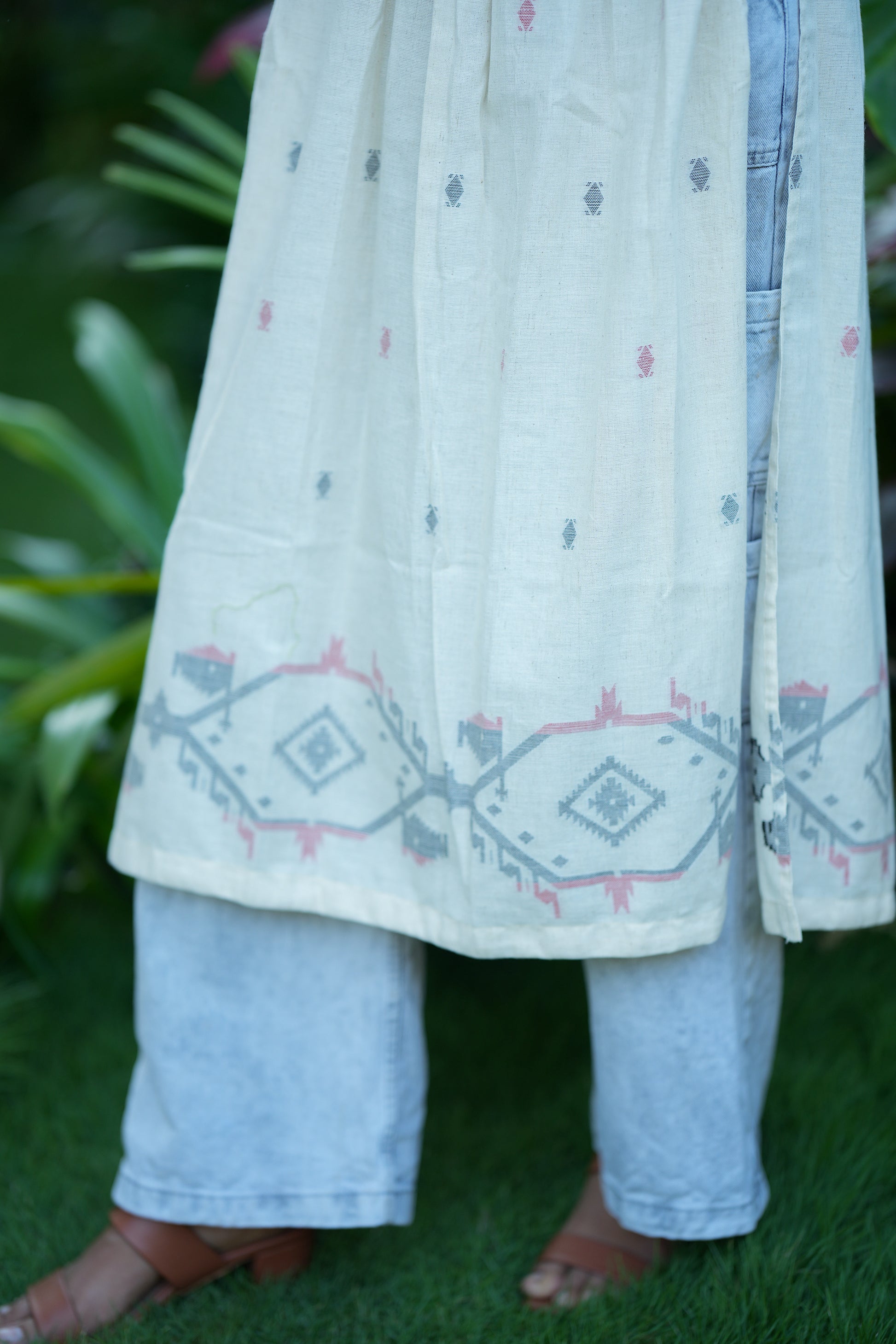 Detailed view of the geometric border print at the hem of the off-white cotton kurti
