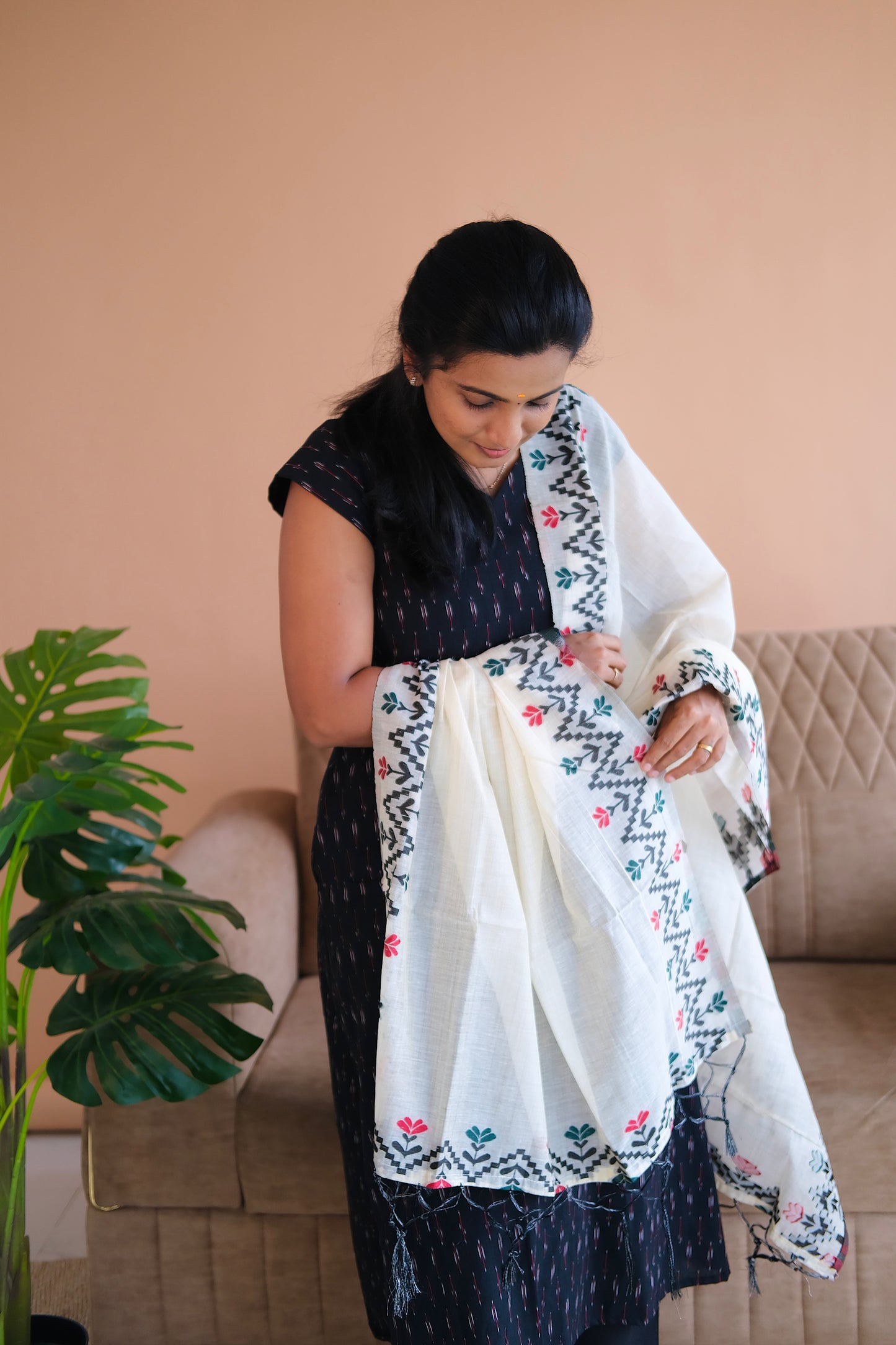 Close-up of the off-white jacquard dupatta with black and red borders and tassels