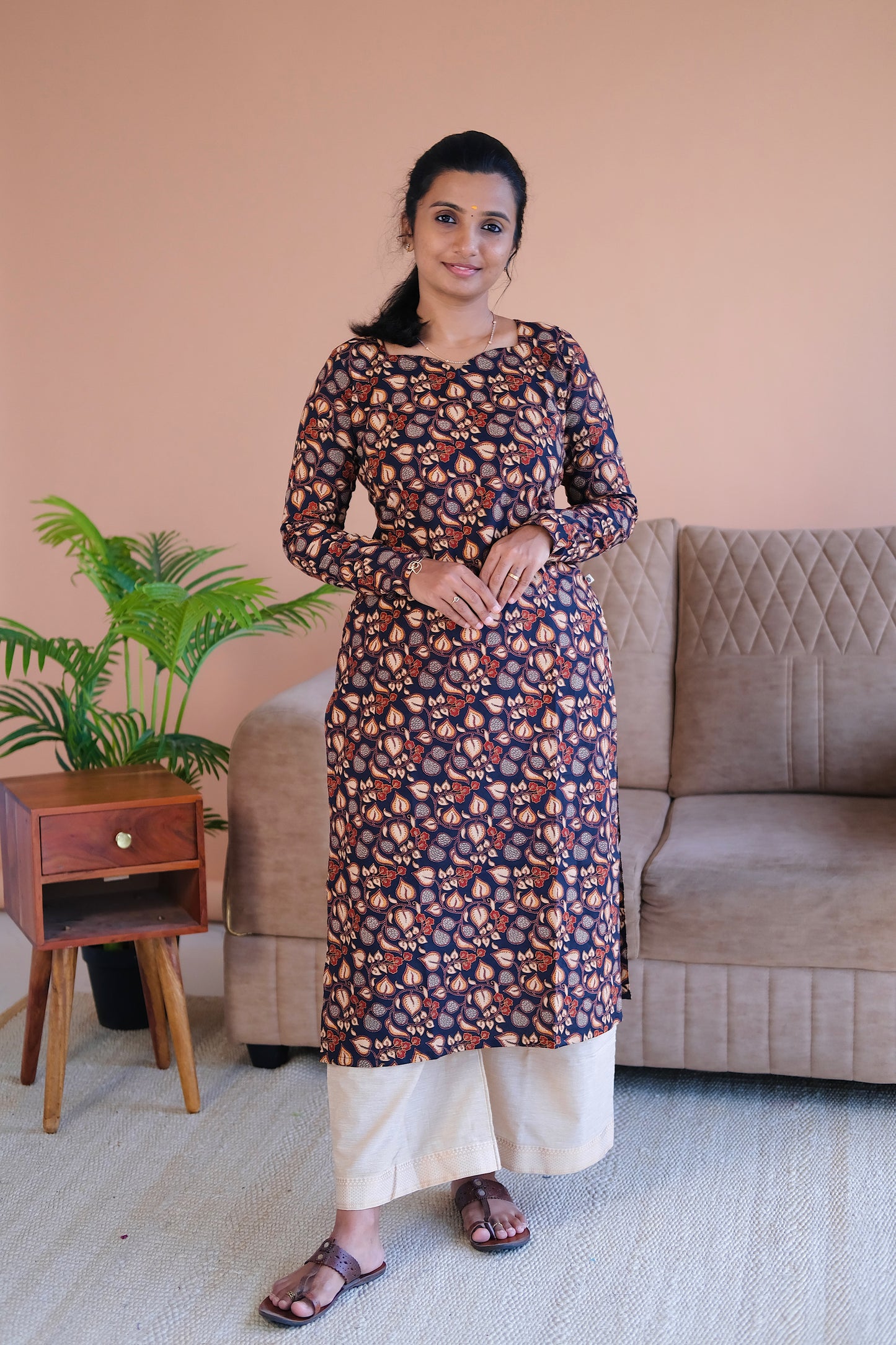 Full-length view of the elegant black printed cotton straight kurti paired with cream trousers.
