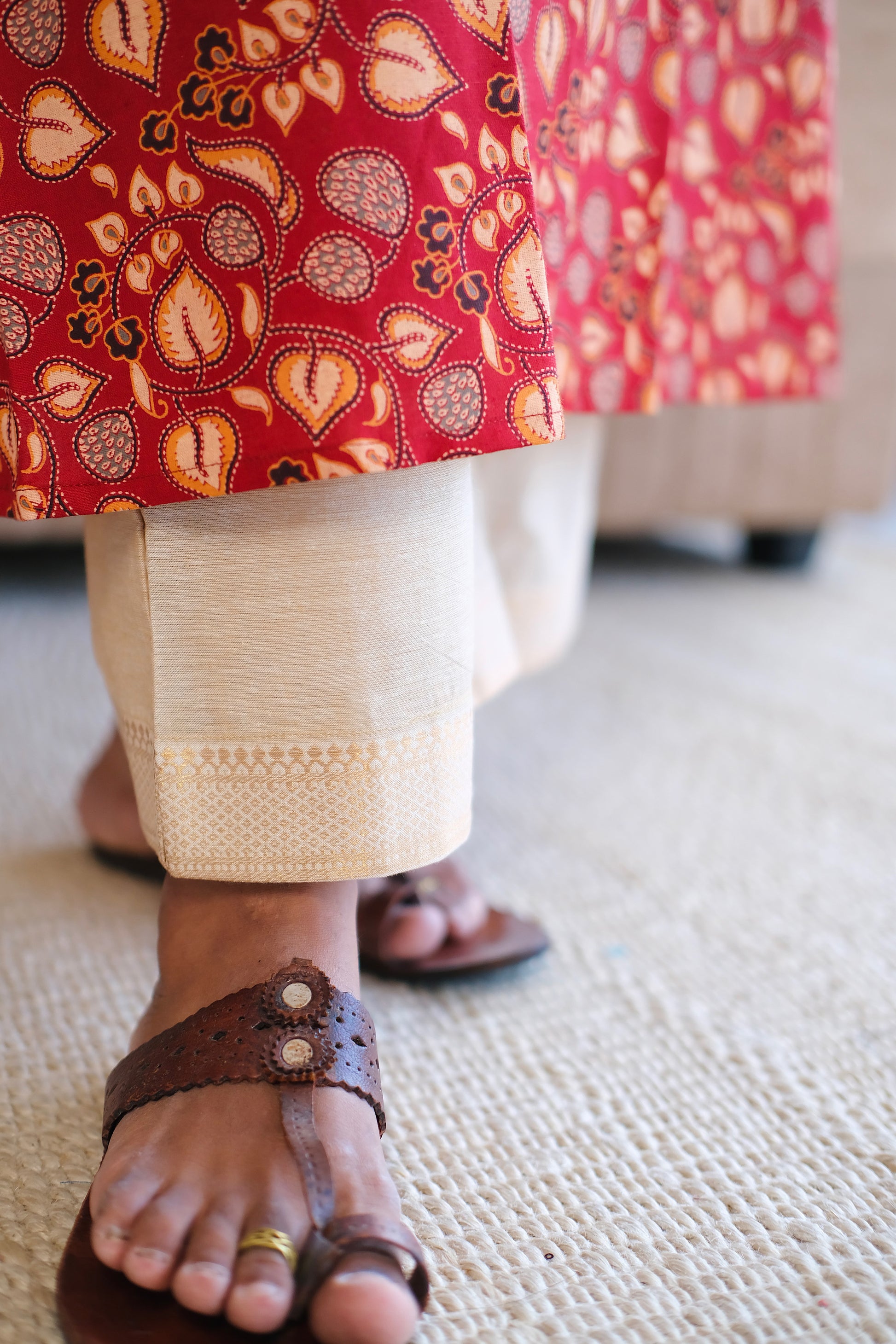 Close-up of the kalamkari-inspired leaf print on the red cotton a line kurti hem