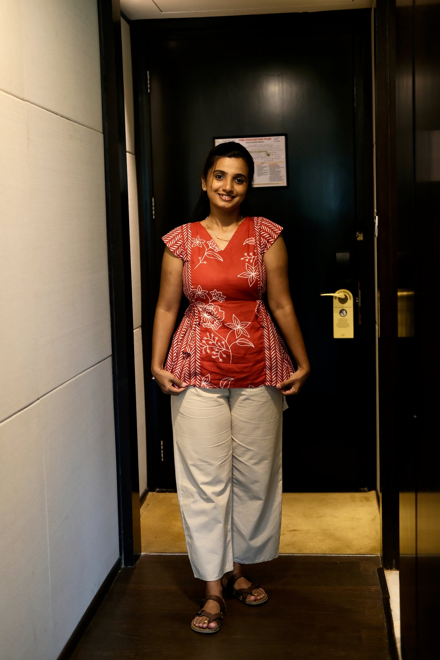 Red printed cotton top with white floral and geometric patterns and a tie-up waist.