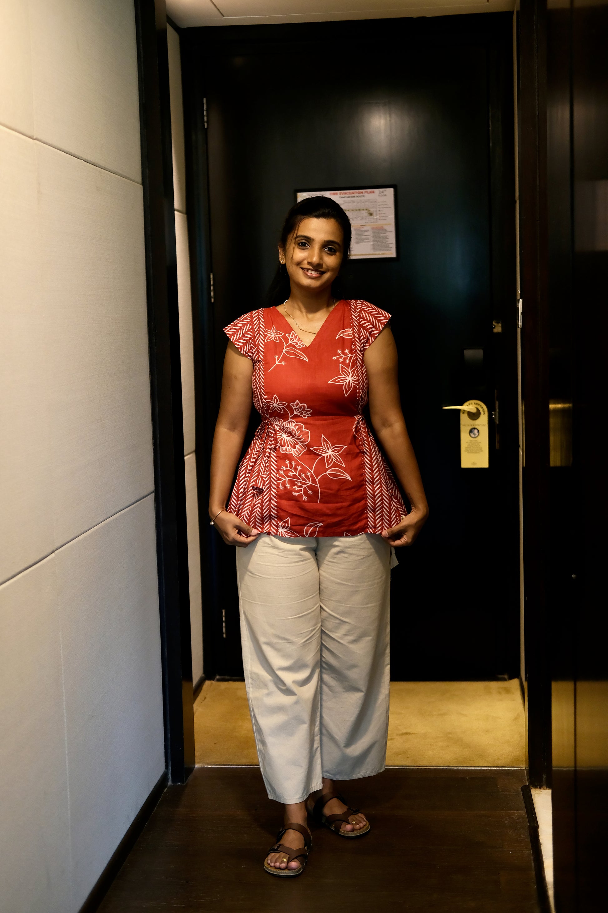Red printed cotton top with white floral and geometric patterns and a tie-up waist.