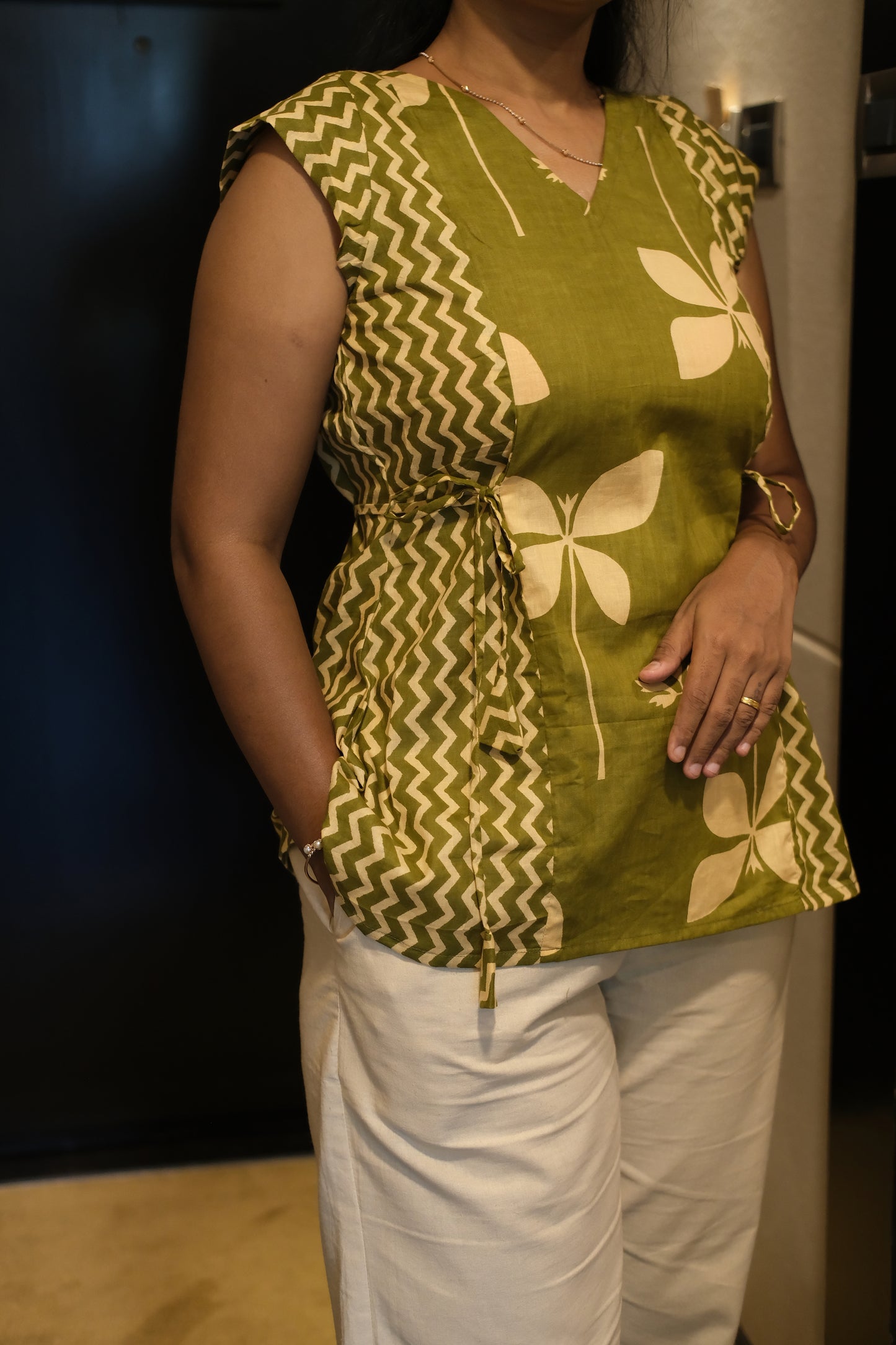Close-up of olive green printed cotton top showing floral and zigzag patterns