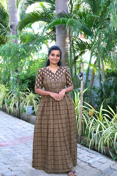 A brown printed cotton maxi nighty featuring a V-shaped yoke design and detailed circular prints with a gathered waist.