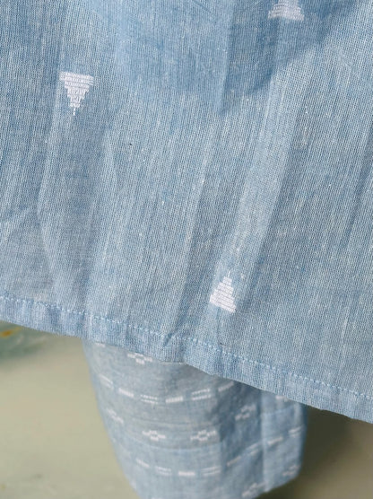 Close-up of the textured sky blue handloom cotton fabric showing the woven white patterns and hemline.