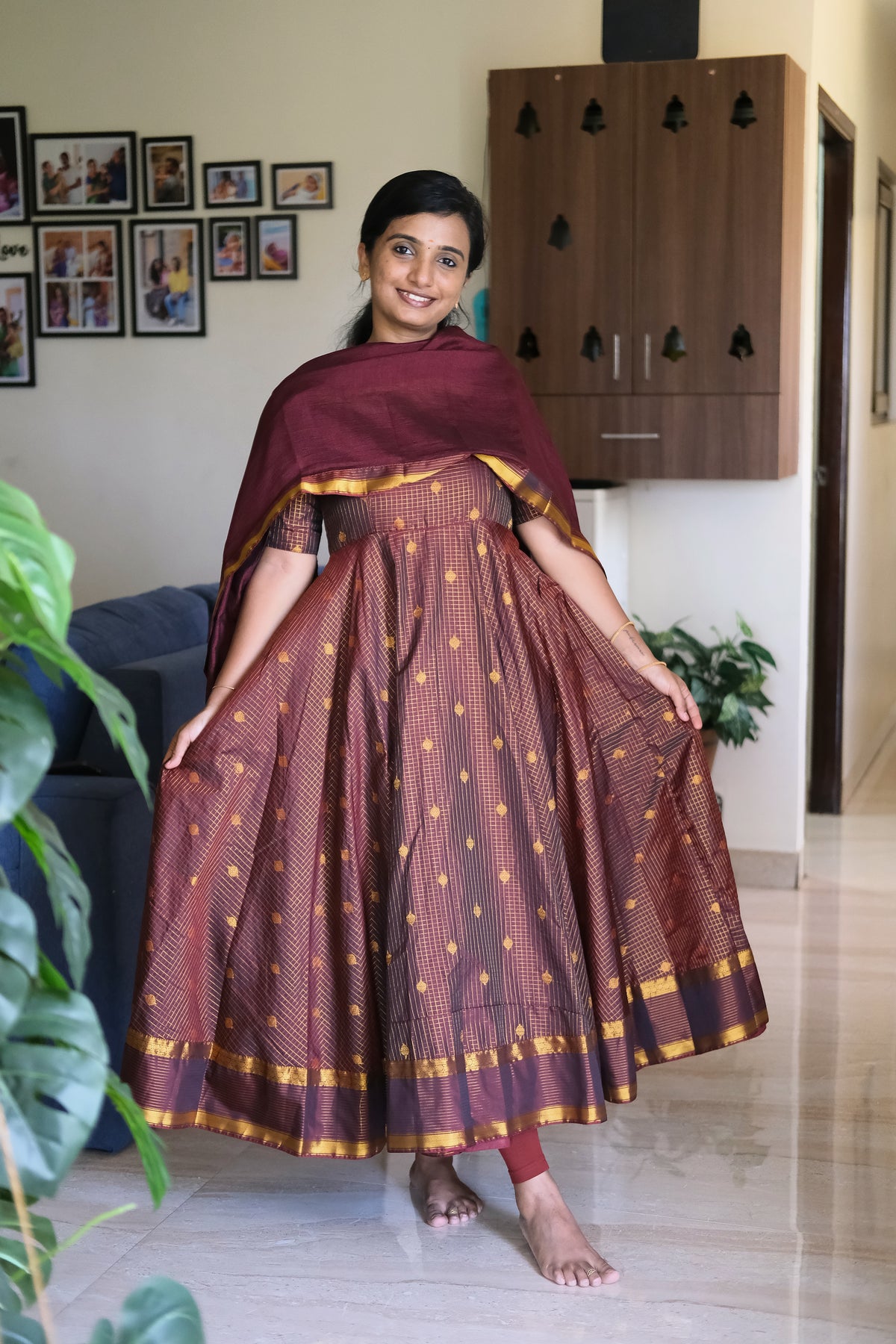 Full length view of golden maroon woven pattu anarkali set with flared silhouette