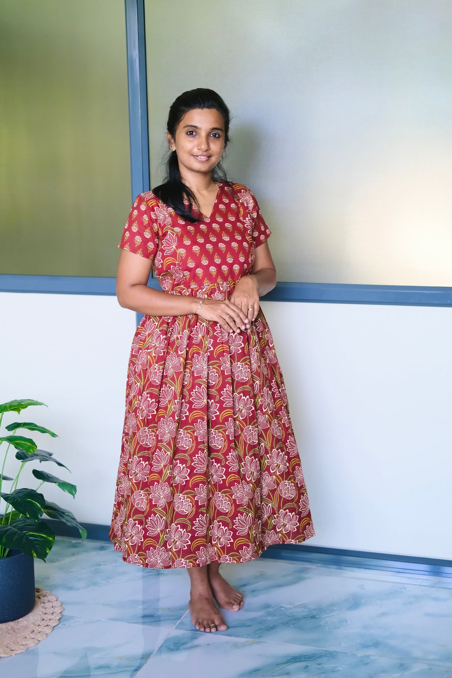A red cotton midi nighty with white and green floral block prints, featuring a gathered waist and short sleeves.