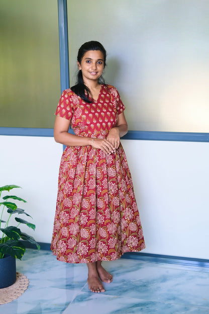 A red cotton midi nighty with white and green floral block prints, featuring a gathered waist and short sleeves.