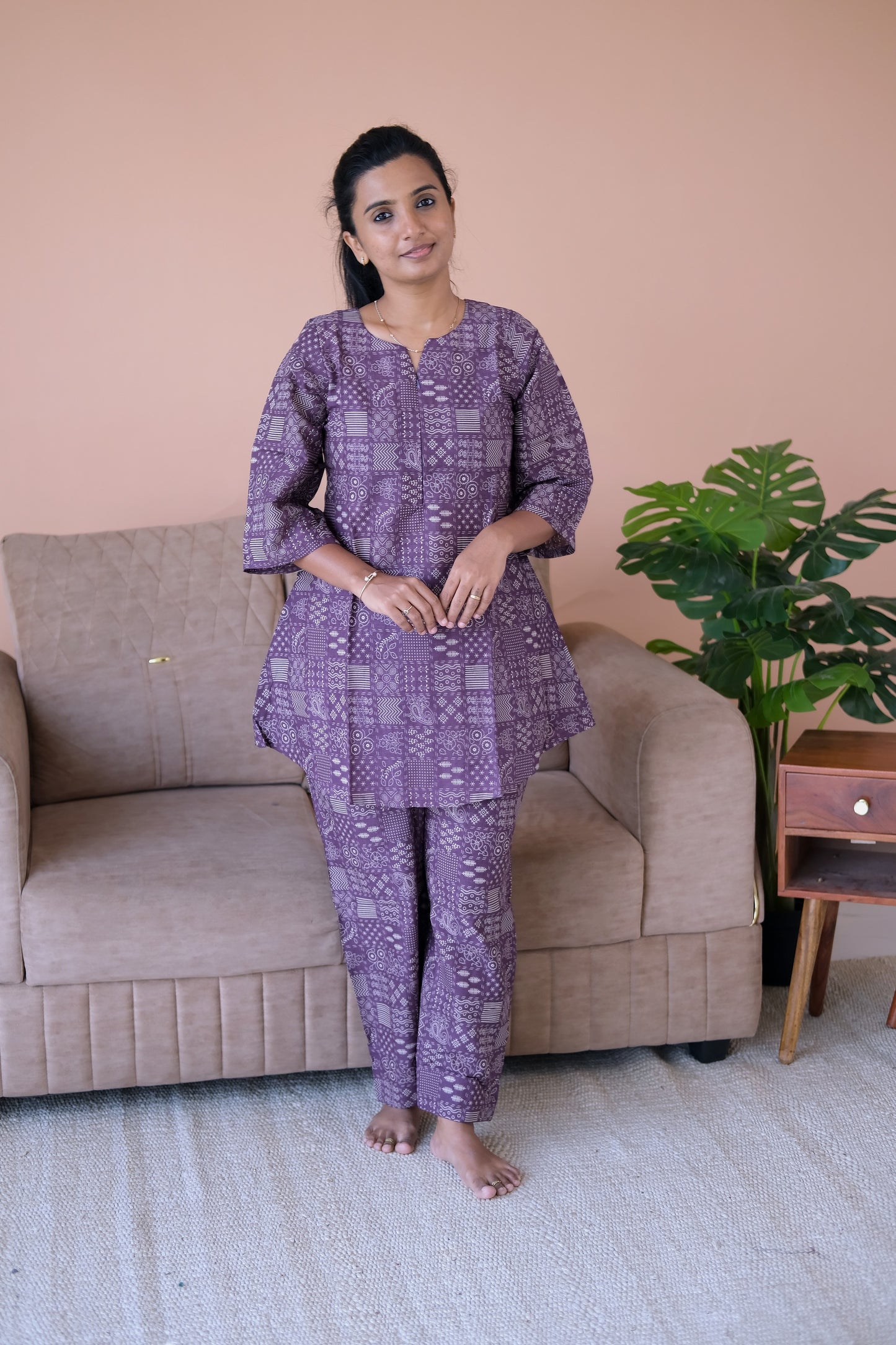 Model standing in a dusty plum cotton loungewear set with traditional white prints and comfortable straight-cut trousers.