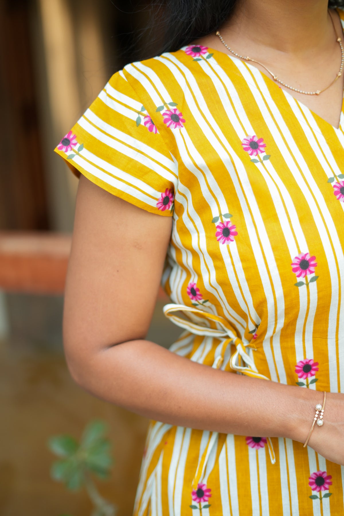 Close-up of the cap sleeve and V-neckline on the yellow striped feeding nighty cotton.
