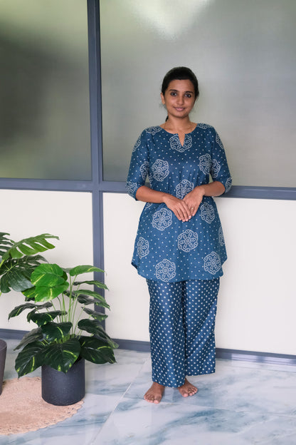Dusty blue cotton night suit for women featuring a flared tunic top with white bandhani prints and matching straight-cut pants.