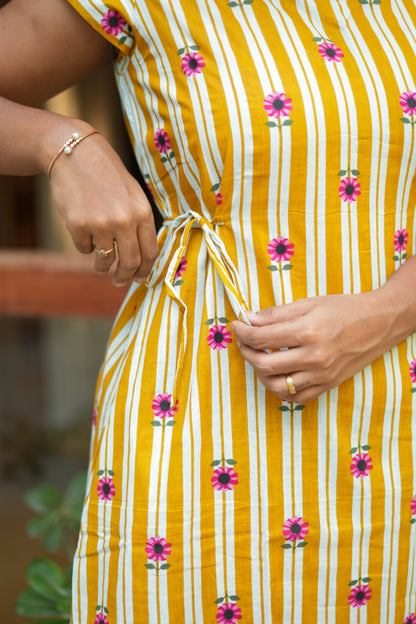 Close-up of the adjustable waist nighty tie detail on a mustard yellow striped cotton fabric.