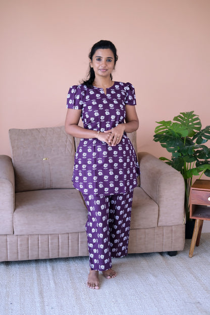 Plum cotton night suit for women featuring a floral printed top with puff sleeves and matching straight pants.