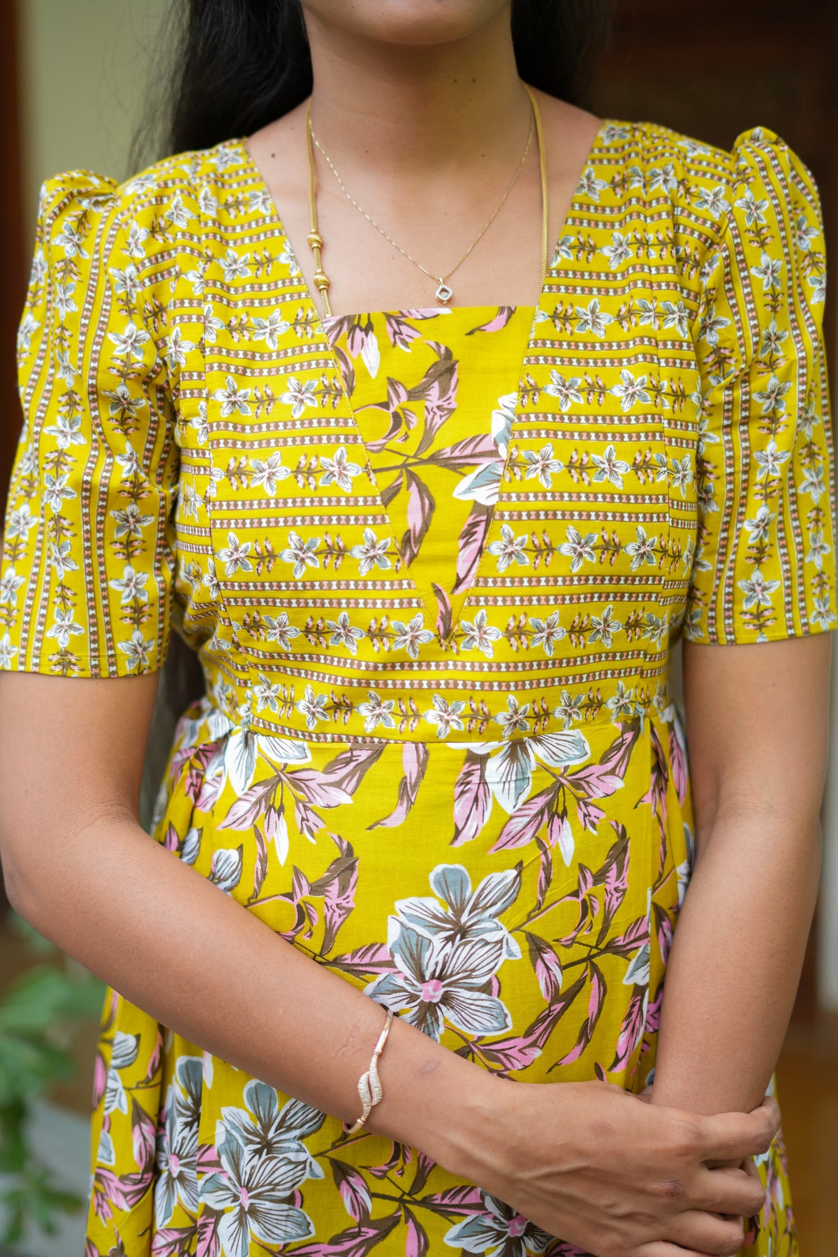 Detailed view of the square neck and puff sleeve design on a mustard yellow cotton maxi nighty.