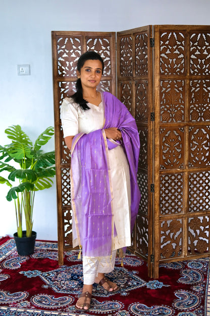 full-length view of the off white raw silk kurti set with a draped lavender dupatta showcasing gold zari borders