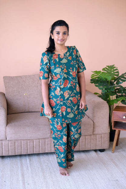Close-up of the Heera deep teal cotton night suit showing the vibrant floral pattern and straight-cut pants.