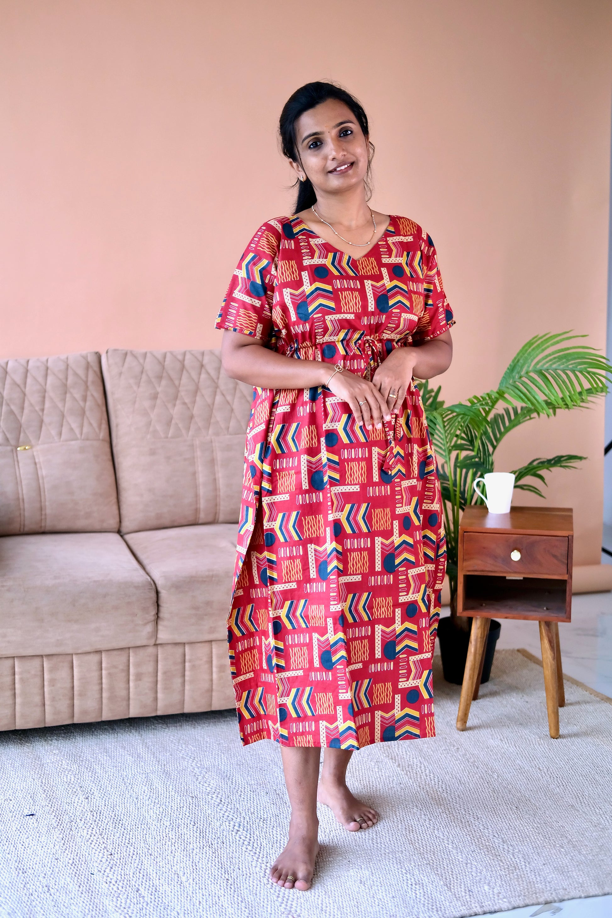 Side view of the red cotton loungewear dress showing the side slit and midi length