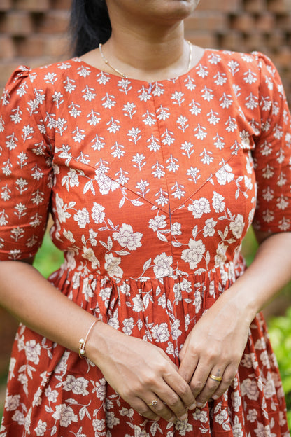 Close-up of the round neckline and yoke detail on the rust red cotton nighty