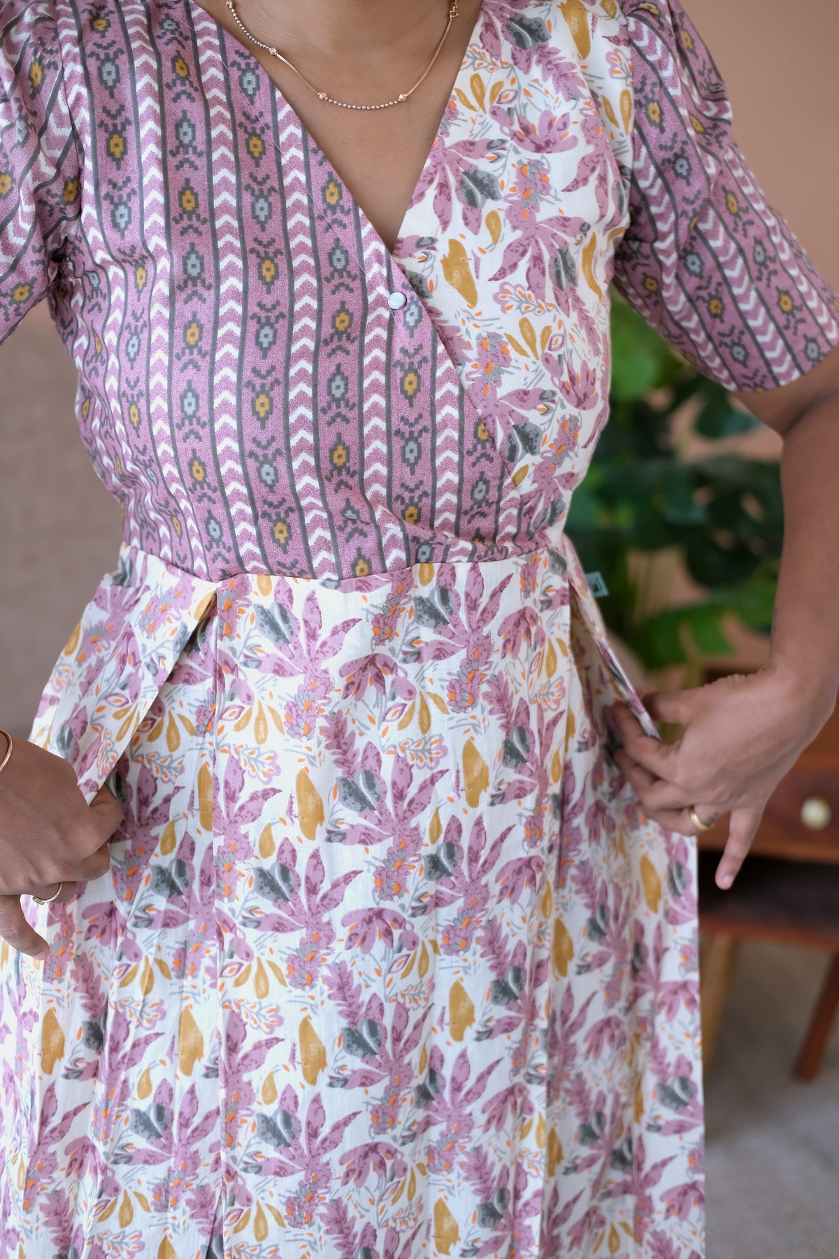Close-up of the crossover V-neckline and functional side pockets on the cotton midi nighty.
