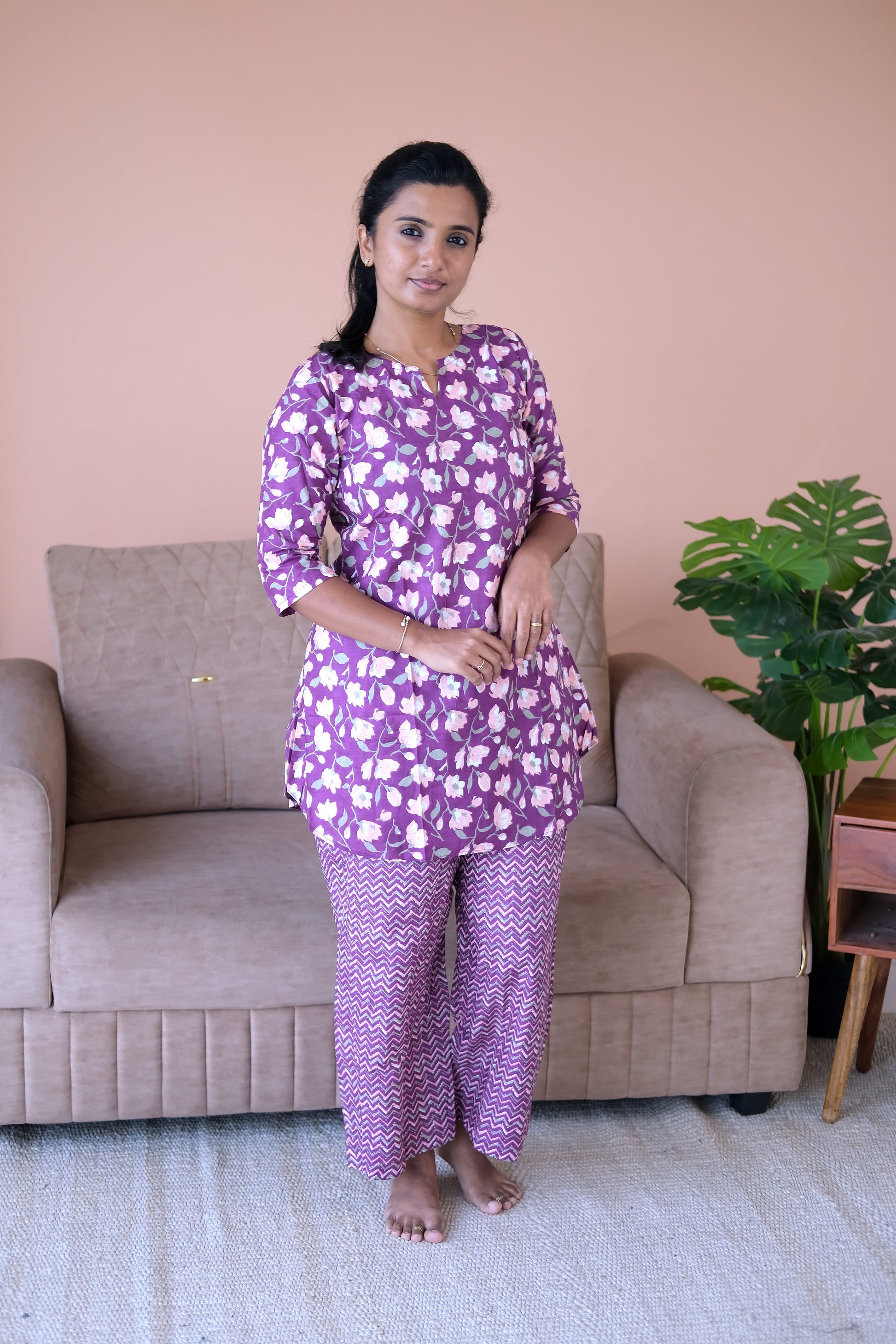 Purple cotton night suit for women featuring a floral print tunic top and matching chevron pants.