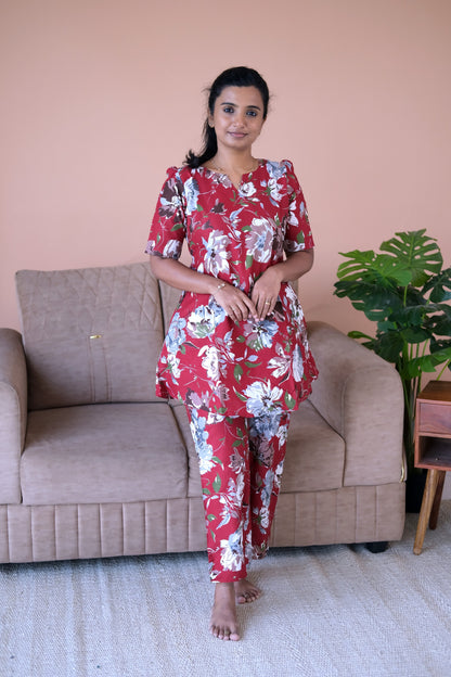 A woman wearing the Heera deep burgundy floral cotton night suit for women, featuring a relaxed-fit top and matching printed pants.