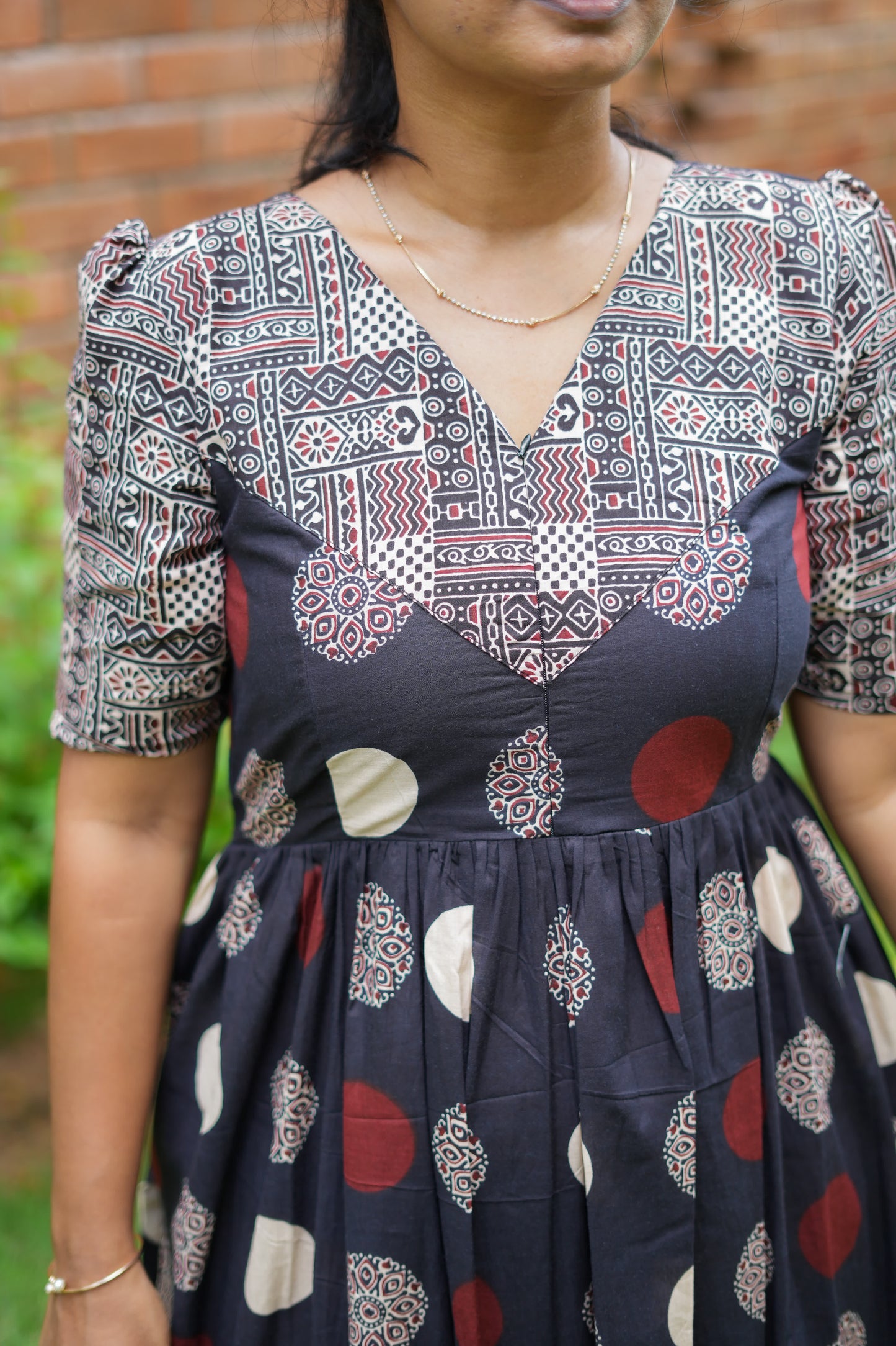 Detailed view of the V-shaped yoke design and hidden feeding zip on the black nighty.
