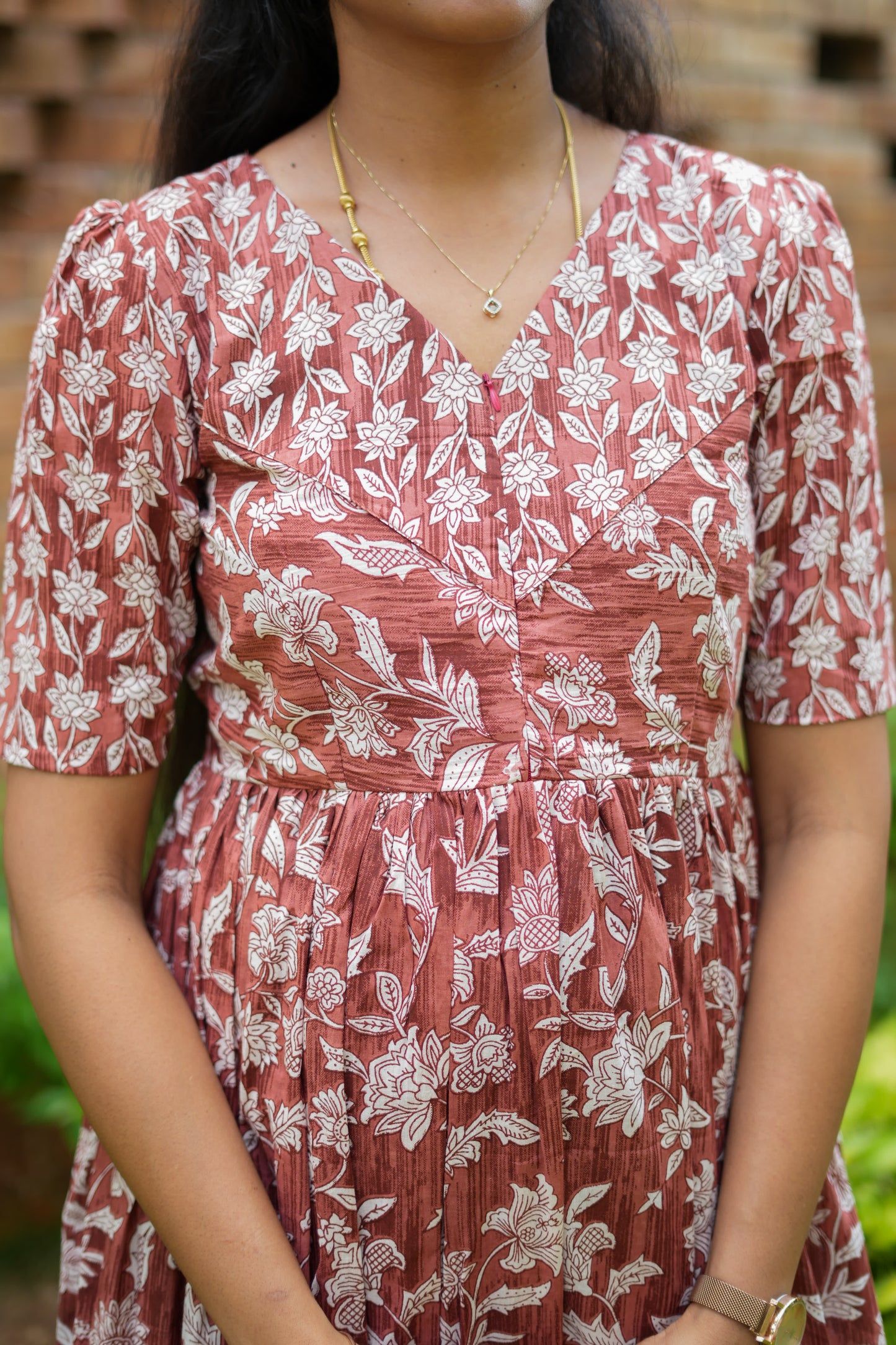 Detailed view of the round neckline and front zipper on a rust brown cotton maxi nighty