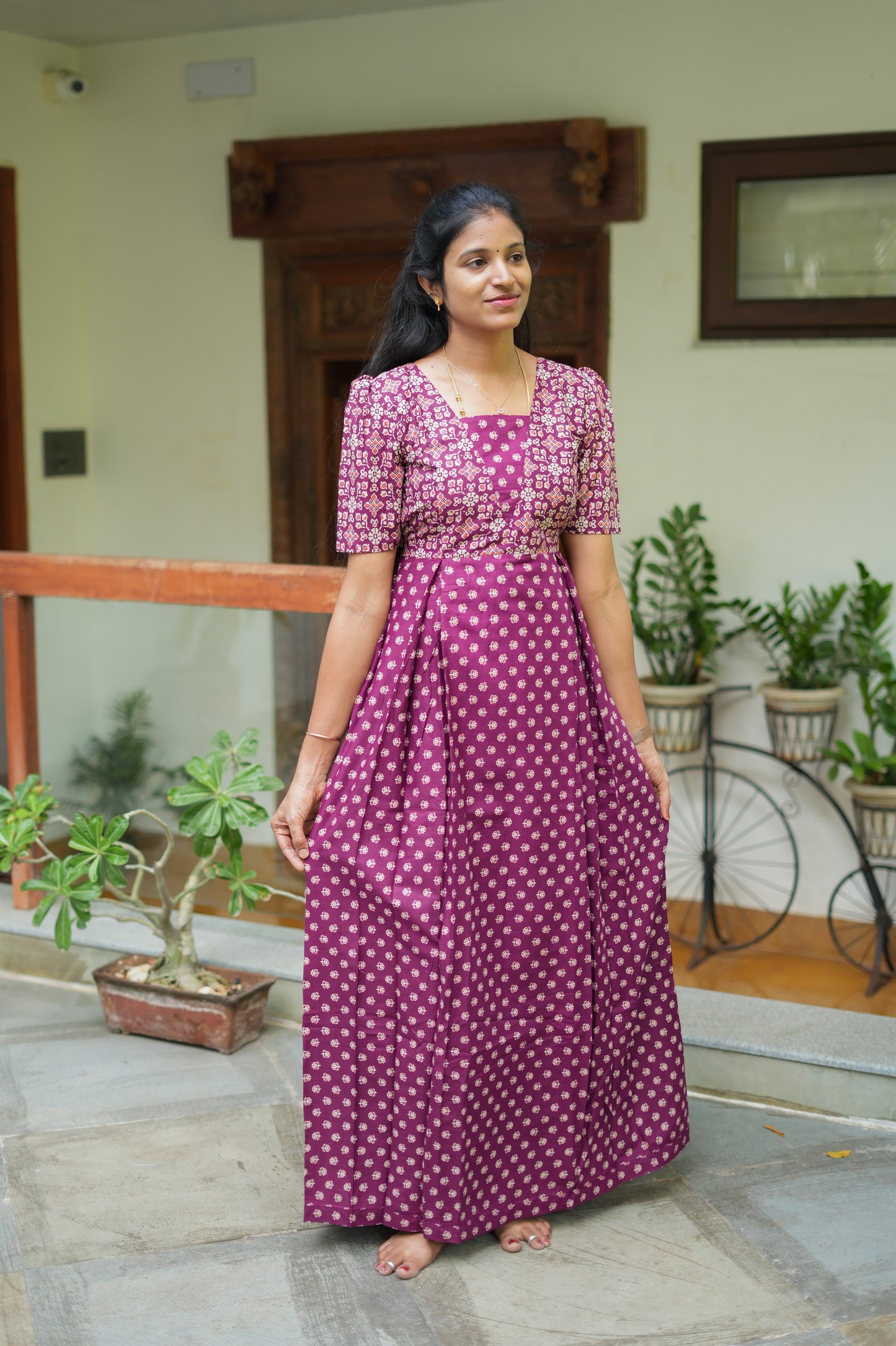 Full-length view of the relaxed fit dark purple maternity cotton nighty with a pleated skirt.